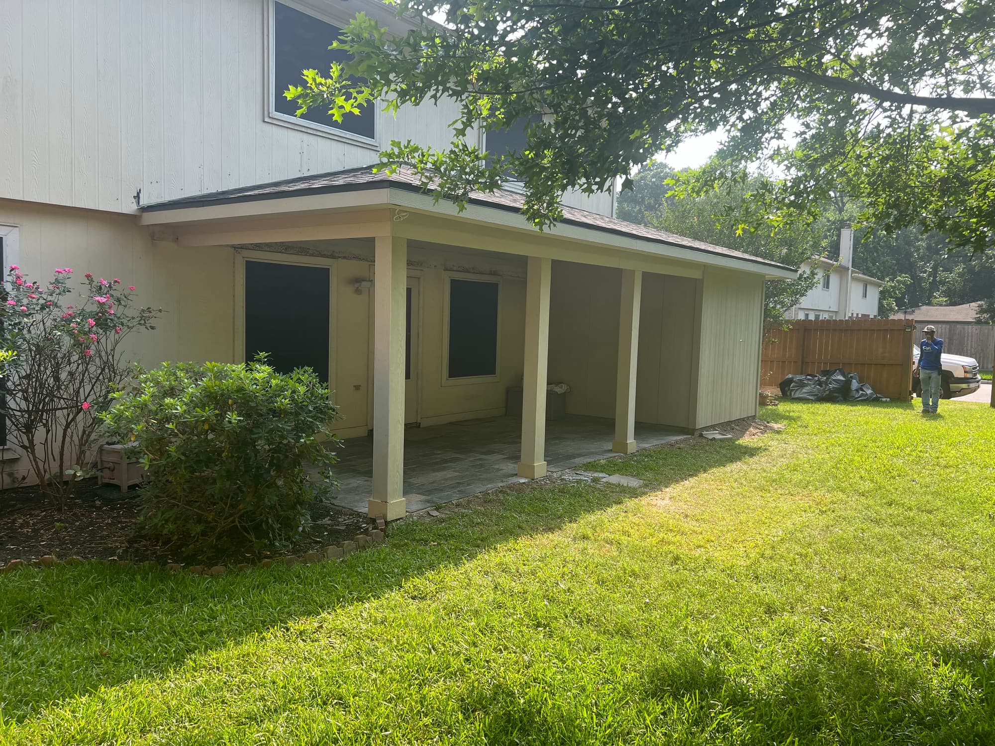 Angled view of the finished covered patio showing the enclosed end wall, soffit and matching roofline